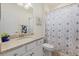Cozy bathroom featuring a granite vanity top, patterned shower curtain and tiled floors at 17610 Polo Trl, Bradenton, FL 34211