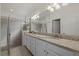 Bathroom with dual sinks, granite countertops, and a glass-enclosed walk-in shower at 17610 Polo Trl, Bradenton, FL 34211