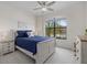 Comfortable bedroom with neutral walls, large window, ceiling fan, and seaside décor at 17610 Polo Trl, Bradenton, FL 34211