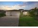 Elegant home with a three-car garage, paver driveway, lush landscaping, and manicured lawn at 17610 Polo Trl, Bradenton, FL 34211