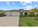 Beautiful home showcasing a well manicured lawn, stone accents, and paver driveway for added curb appeal at 17610 Polo Trl, Bradenton, FL 34211
