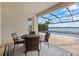 Screened lanai featuring a table with seating for four, overlooking the pool and waterfront at 17610 Polo Trl, Bradenton, FL 34211