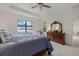 Bright main bedroom featuring a large window with stunning waterfront views and a decorative dresser at 17610 Polo Trl, Bradenton, FL 34211