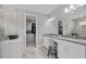 Elegant bathroom with double vanity, white cabinetry, and marble floors, with a large walk-in closet at 17814 Cresswind Ter, Bradenton, FL 34211