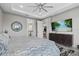 Bright bedroom features a ceiling fan, TV on a credenza, and an ensuite bathroom and closet at 17814 Cresswind Ter, Bradenton, FL 34211