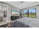 Well-lit bedroom features a large window with backyard views, tray ceiling, and stylish furnishings at 17814 Cresswind Ter, Bradenton, FL 34211