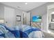 Serene bedroom with a modern TV, light gray walls, and a coordinating blue and white bedding set at 17814 Cresswind Ter, Bradenton, FL 34211