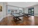 Elegant billiards room with two tables, hardwood floors, and a view into a stylish seating area at 17814 Cresswind Ter, Bradenton, FL 34211