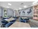 Stylish common room with wood tables, blue chairs, and decorative artwork on the textured blue walls at 17814 Cresswind Ter, Bradenton, FL 34211