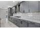Modern kitchen showcasing sleek gray cabinetry, granite countertops, stainless steel appliances, and ample storage at 17814 Cresswind Ter, Bradenton, FL 34211