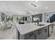 Kitchen island with sink, stainless steel dishwasher, and lovely view of the dining and living area at 17814 Cresswind Ter, Bradenton, FL 34211