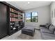 Comfortable home office with custom built-in shelving, a cozy sofa, and a large window at 17814 Cresswind Ter, Bradenton, FL 34211