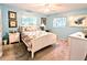 Light blue bedroom features neutral carpet, ceiling fan, and two windows for natural light at 2057 Sunset Dr # G1, Bradenton, FL 34207