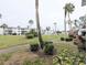 Well-manicured community grounds with mature landscaping, sidewalks and nearby complex at 2057 Sunset Dr # G1, Bradenton, FL 34207