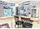 Bright kitchen bar area features two stools, granite counters, wine rack and elegant stemware rack at 2057 Sunset Dr # G1, Bradenton, FL 34207