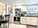 View of kitchen featuring stainless steel appliances, white cabinetry, tile backsplash, and granite countertops at 2057 Sunset Dr # G1, Bradenton, FL 34207