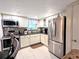 View of kitchen featuring stainless steel appliances, white cabinetry, tile backsplash, and granite countertops at 2057 Sunset Dr # G1, Bradenton, FL 34207