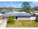 An eye-level view of the house, a single story with a grey roof and a green lawn at 2406 25Th W Ave, Bradenton, FL 34205