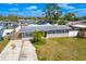 An aerial view of the front of this single-story house, with a grey roof and green yard at 2406 25Th W Ave, Bradenton, FL 34205