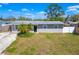 An aerial view of the front of this single-story house, with a grey roof and green yard at 2406 25Th W Ave, Bradenton, FL 34205