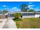 An aerial view of the front of this single-story house, with a grey roof and green yard at 2406 25Th W Ave, Bradenton, FL 34205