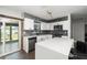 Open-concept kitchen with stainless steel appliances, white cabinets, and hardwood flooring at 2406 25Th W Ave, Bradenton, FL 34205