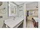 Bathroom with a modern vanity, decorative mirror, and an adjacent bedroom at 250 Santa Maria St # 215, Venice, FL 34285
