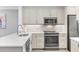 Updated kitchen boasts stainless appliances, light gray cabinets, and white countertops at 250 Santa Maria St # 215, Venice, FL 34285