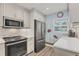 Charming kitchen features stainless appliances, light gray cabinets and a colorful floral mural at 250 Santa Maria St # 215, Venice, FL 34285