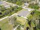 Aerial view of a well-maintained home with a fenced yard surrounded by lush greenery and neighboring houses at 2721 Burri Ter, North Port, FL 34288