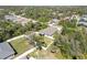 An aerial view showcasing a home surrounded by a white fence, green grass, and many trees at 2721 Burri Ter, North Port, FL 34288