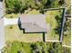 Aerial view of a well-maintained home with a fenced yard surrounded by lush greenery and neighboring houses at 2721 Burri Ter, North Port, FL 34288