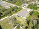 Aerial view of a well-maintained home with a fenced yard surrounded by lush greenery and neighboring houses at 2721 Burri Ter, North Port, FL 34288