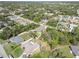 The aerial shows a house with a fenced-in backyard, trees, and a neighborhood with similar houses and foliage at 2721 Burri Ter, North Port, FL 34288