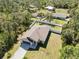Aerial view of a well-maintained home with a fenced yard surrounded by lush greenery and neighboring houses at 2721 Burri Ter, North Port, FL 34288