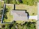 Aerial view of a well-maintained home with a fenced yard surrounded by lush greenery and neighboring houses at 2721 Burri Ter, North Port, FL 34288
