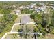 Aerial shot features a cozy home with a fenced backyard, and lush green trees surrounding the property at 2721 Burri Ter, North Port, FL 34288