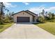 Charming single-story home with a two-car garage, well-manicured lawn, and inviting front entrance at 2721 Burri Ter, North Port, FL 34288