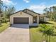 Charming single-story home with a spacious driveway, lush lawn, and well-maintained landscaping at 2721 Burri Ter, North Port, FL 34288