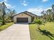 Charming single-story home with a spacious driveway, lush lawn, and well-maintained landscaping at 2721 Burri Ter, North Port, FL 34288