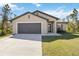 Charming single-story home with a two-car garage, well-manicured lawn, and inviting front entrance at 2721 Burri Ter, North Port, FL 34288