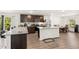 Stylish kitchen featuring dark wood cabinetry, stainless appliances, granite counters and island seating at 2721 Burri Ter, North Port, FL 34288
