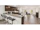 Open-concept kitchen with stainless steel appliances, granite countertops, an island with seating and gray flooring at 2721 Burri Ter, North Port, FL 34288