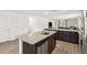 Spacious kitchen with granite countertops, stainless steel dishwasher and a view into the living room at 2721 Burri Ter, North Port, FL 34288