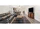 Inviting living room with modern gray flooring, black leather couches, and an open layout to the kitchen at 2721 Burri Ter, North Port, FL 34288