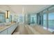 Bright bathroom with marble finishes, a soaking tub, and floor-to-ceiling windows with waterfront views at 280 Golden Gate Pt # 400, Sarasota, FL 34236