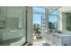 Modern bathroom featuring a walk-in glass shower and a vanity with large windows at 280 Golden Gate Pt # 400, Sarasota, FL 34236