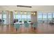 Dining room with hardwood floors, modern lighting, and stunning waterfront views through large windows at 280 Golden Gate Pt # 400, Sarasota, FL 34236