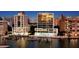Waterfront luxury building featuring a pool and dock against city lights and water at 280 Golden Gate Pt # 400, Sarasota, FL 34236