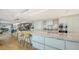 Open-concept kitchen with island, marble countertops, modern appliances, and seamless flow to dining and living areas at 280 Golden Gate Pt # 400, Sarasota, FL 34236